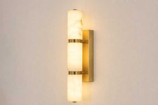 Brass and alabaster wall sconce mounted on a wall